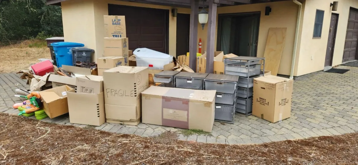 Boxes and household belongings staged outside garages